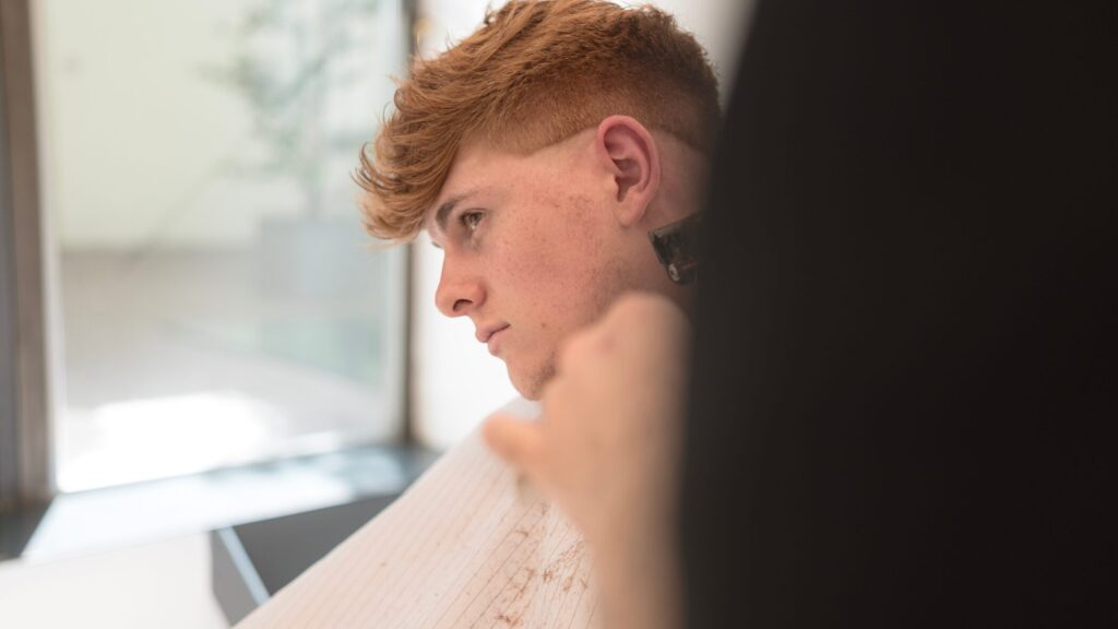 Mann im Gespräch mit dem Friseur und Barbier, um den perfekten Haarschnitt zu besprechen und den Look zu pflegen.